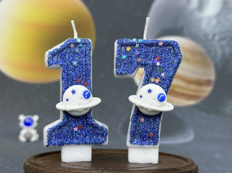 Velas azules con brillo con forma de números 1 y 7, cada una decorada con una figura de planeta blanca con ojos azules, para velas de cumpleaños numerales temáticas del espacio, fiesta planetaria, adorno para pastel.