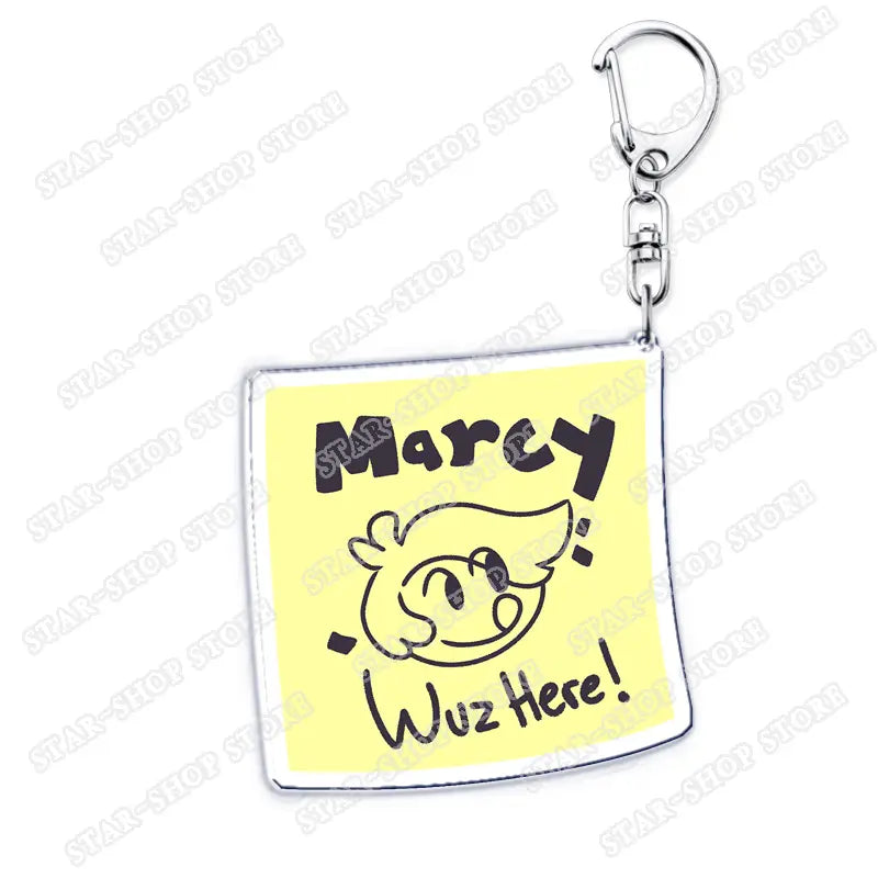 Yellow square acrylic keychain featuring a cartoon character and black lettering saying marcy wuz here from the Amphibia anime series.