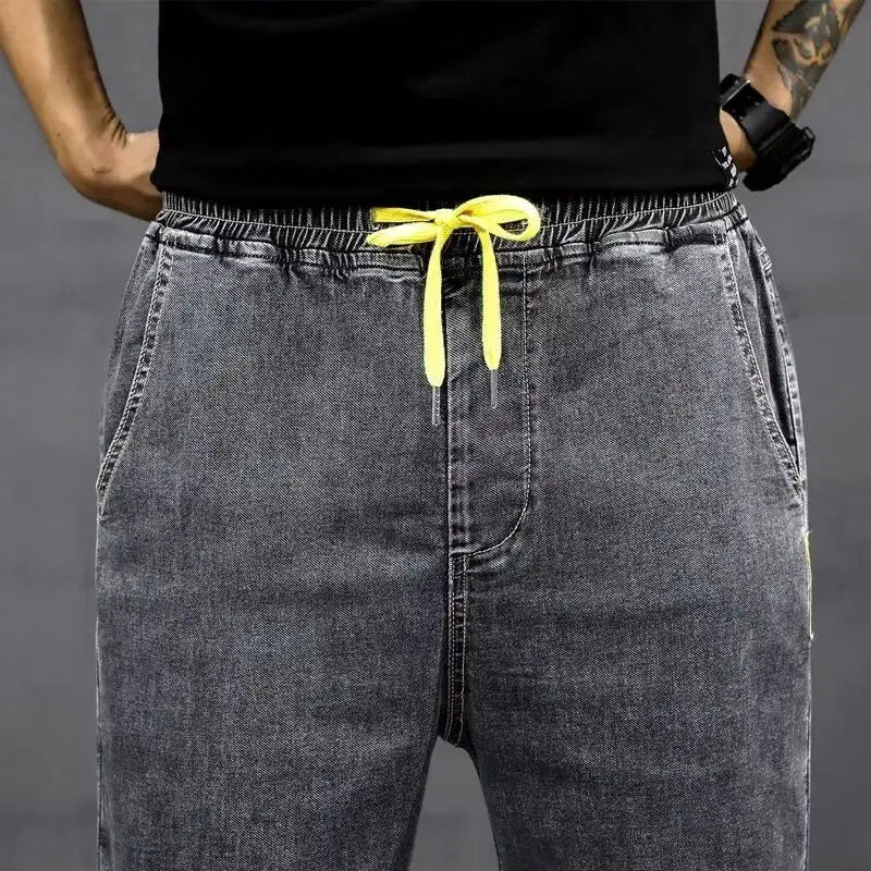 Pantalons de jogging en denim gris ample pour homme avec une cordelette jaune vif, idéaux pour une tenue de travail décontractée d’été.
