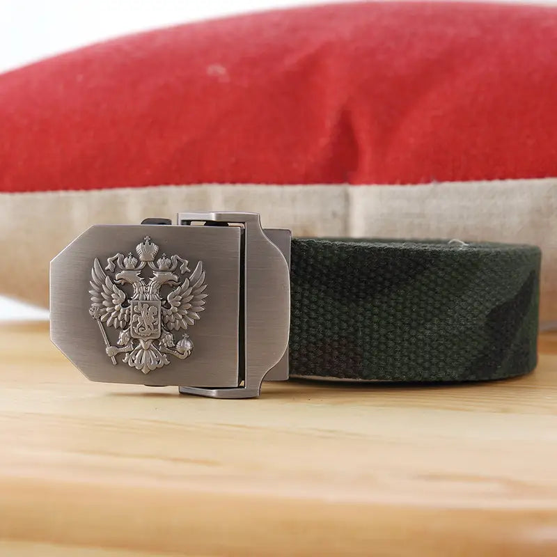 Boucle de ceinture à finition ton argent avec un emblème d’aigle bicéphale en relief, associée à une sangle en toile camouflage vert foncé sur une ceinture tactique en toile à aigle russe pour hommes, pour un usage militaire.