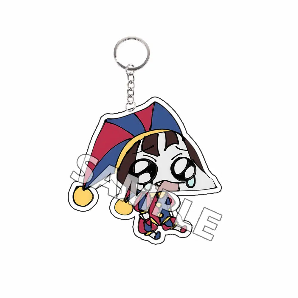 Producto terminado de llavero acrílico tipo Tadc que presenta una figura estilo chibi colorida con un sombrero de bufón rojo, azul y amarillo con cascabeles dorados.
