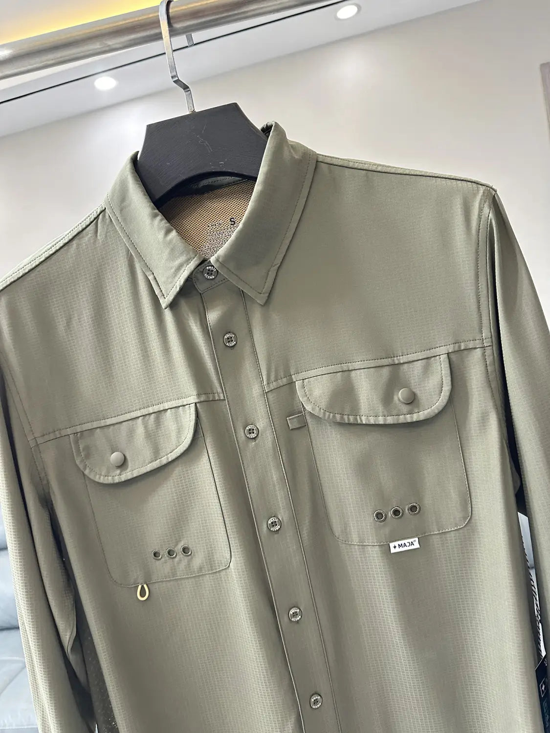 A khaki-colored men’s tactical outdoor long sleeve shirt featuring two chest pockets and subtle textured fabric.