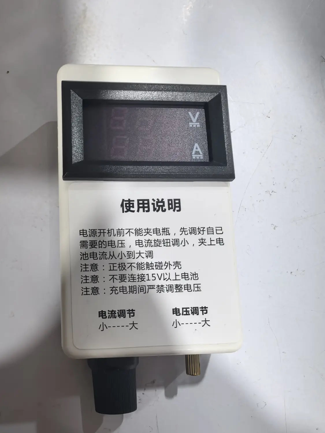 Régulateur de courant et de tension numérique rectangulaire blanc avec écran numérique noir affichant les mesures de tension et de courant, et instructions d’utilisation en chinois sur le panneau avant pour des applications de 50 A, 60 A et 100 A.
