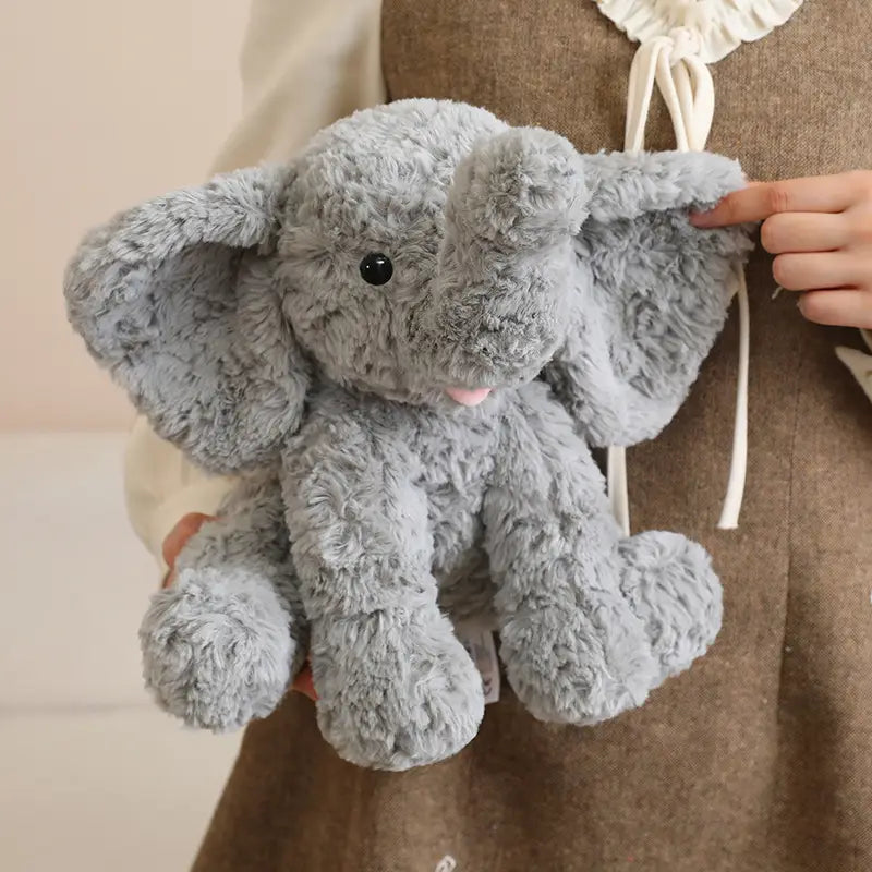 A plush stuffed animal toy 25cm soft light gray plush elephant backpack with fluffy texture and pink tongue detail.