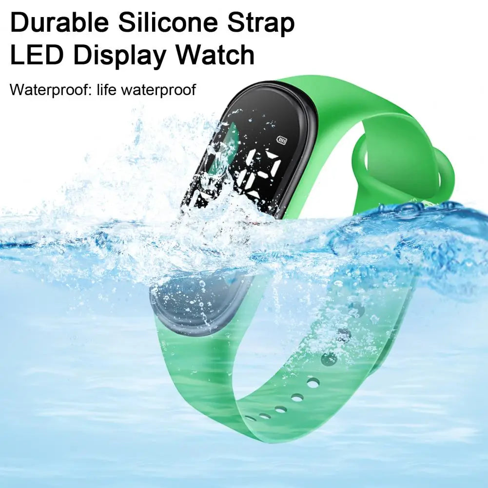Reloj electrónico con correa de silicona verde, con pantalla de letra grande y pantalla digital negra, diseñado como reloj deportivo digital impermeable.
