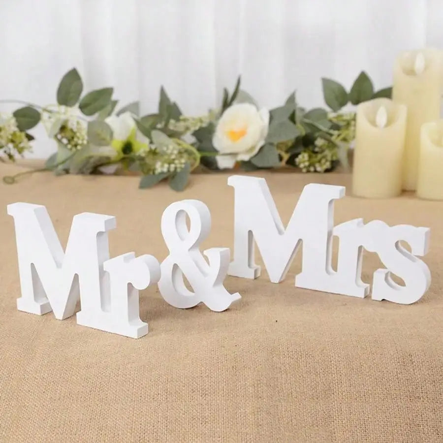 Weißes hölzernes Hochzeitstischschild mit dem Wort „Mr“ als Bestandteil der Dekoration „Mr und Mrs“.