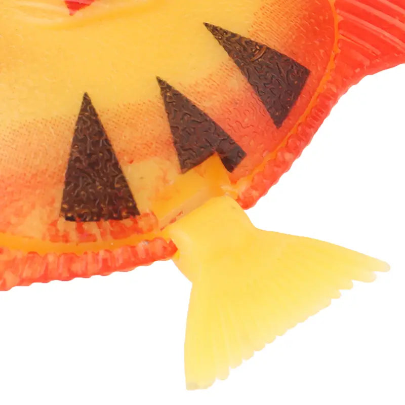 A vibrant orange and yellow plastic floating fish toy with black triangular teeth designed for aquarium fish decoration in a 10 pack.