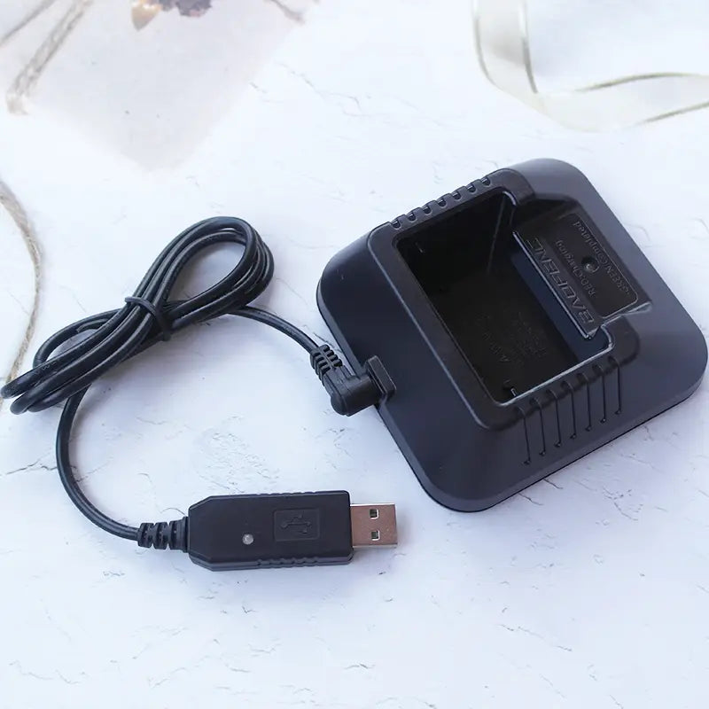 バオフェン携帯型トランシーバー用の黒色プラスチック製USB充電ケーブルデスクトップ充電器で、コイル状のケーブルと長方形の充電スロットを備えています。