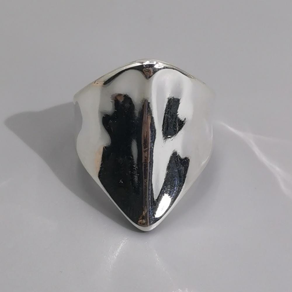 A sleek silver-toned geometric open ring with a bold shield-shaped face and polished metallic finish in silver and gold metal jewelry.