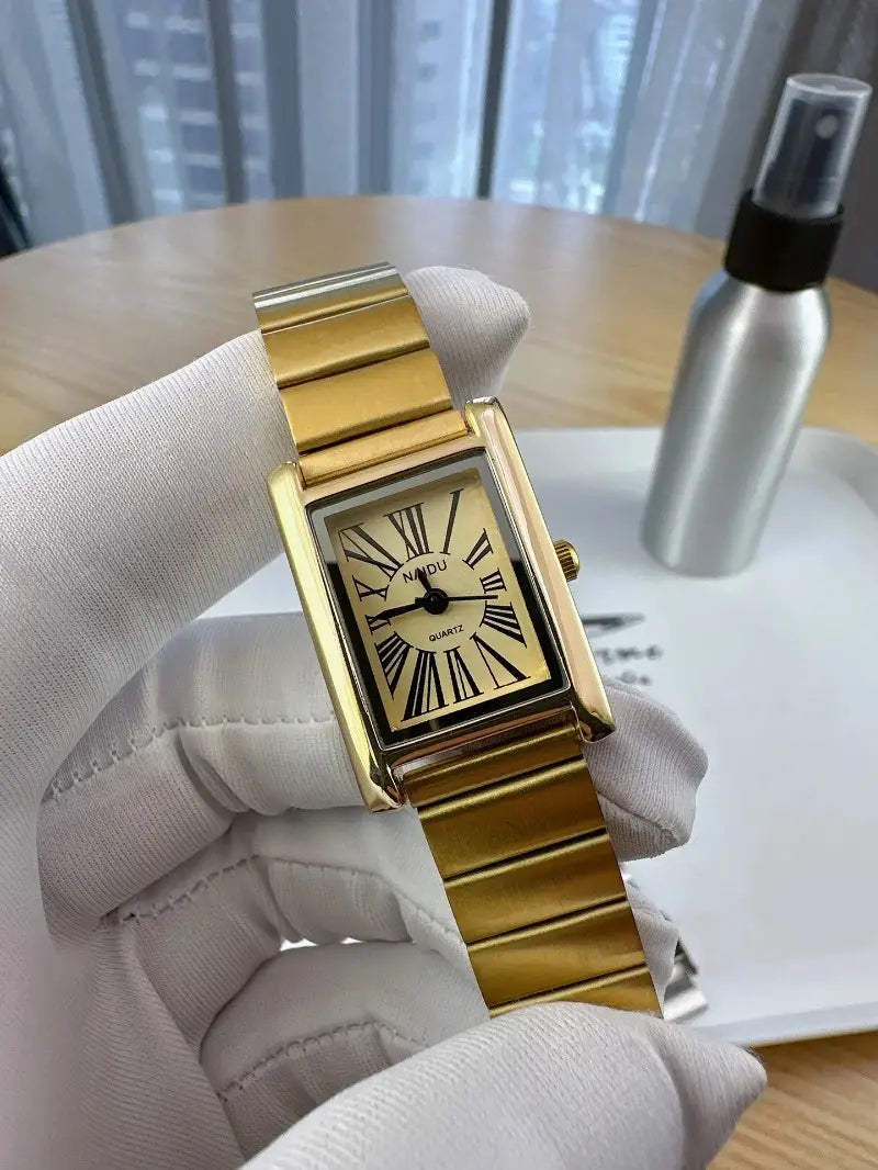 Vintage gold rectangular quartz watch for women with roman numerals and a sleek metallic band.