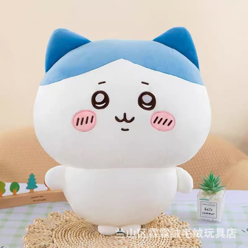 Lindo peluche blanco de chiikawa usagi, con orejas azules, mejillas rosadas y una textura suave y acogedora hecha de material de peluche.