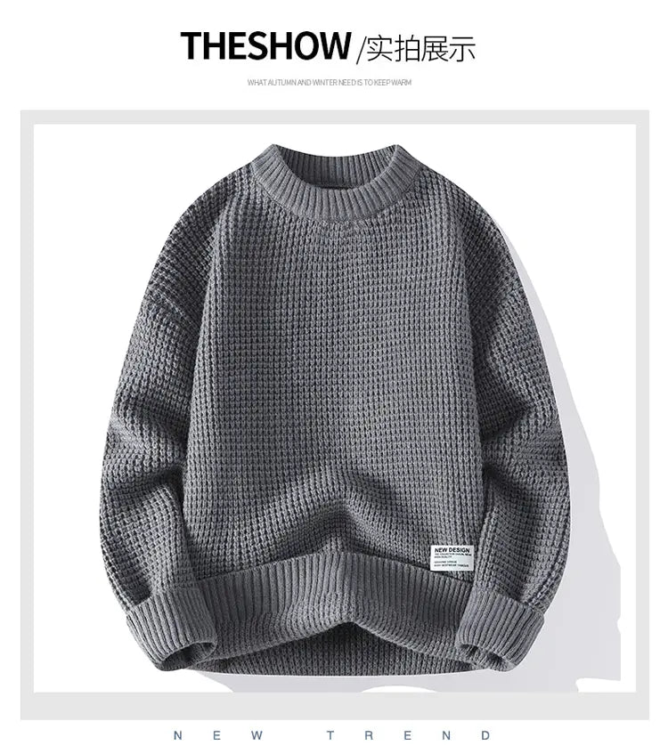 Grauer Waffelstrick-Pullover im lässigen Stil mit Rundhalsausschnitt von Moownuc mit gerippten Bündchen und Saum sowie einem kleinen Markenpatch auf dem unteren linken Ärmel.