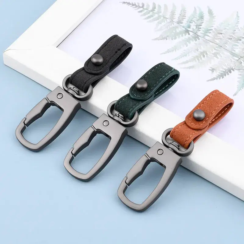Leder-Schlüsselanhänger im 3er-Set als Organizer für Autotasten mit drei Lederriemen in Schwarz, Grün und Braun sowie Metall-Karabinerhaken.