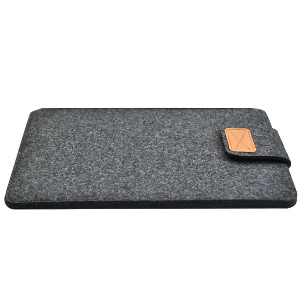 Dark gray felt laptop bag with a tan leather flap closure designed as a laptop bag felt sleeve for MacBook Air.