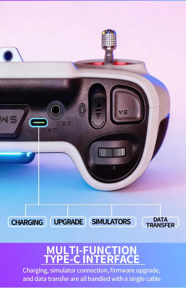 Télécommande du transmetteur radio FPV Edgetx V12 en blanc et noir : elle présente une poignée texturée, un dessus de joystick en métal et des ports étiquetés pour la charge, la mise à niveau, les simulateurs et le transfert de données.