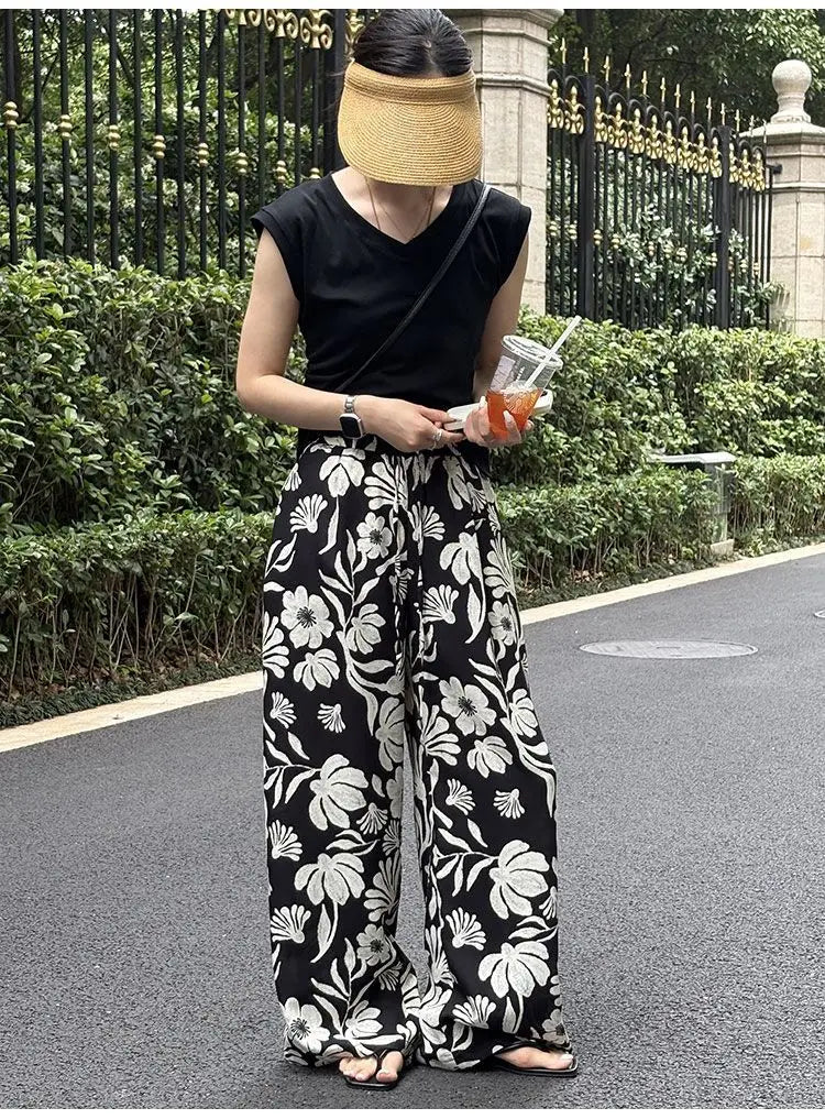 pantalons à jambes évasées avec imprimé floral noir et blanc pour femmes, offrant une coupe fluide et confortable ainsi qu’un design élégant, idéal pour les tenues décontractées et semi-formelles