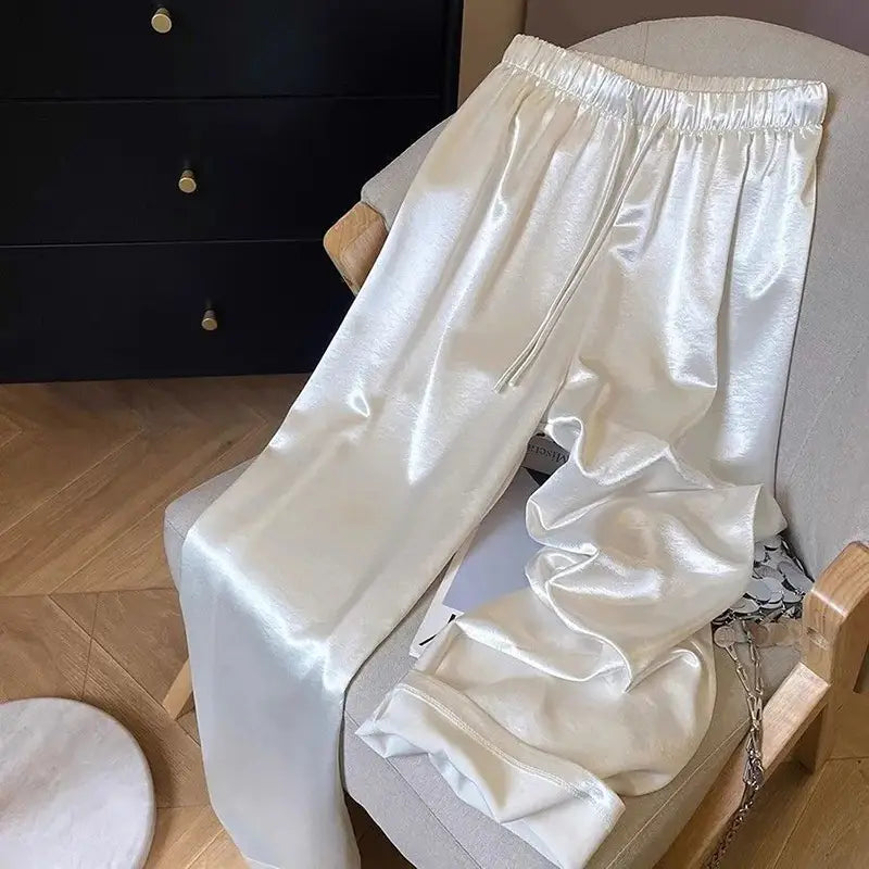 Glänzende weiße Satin-Hosen mit weitem Bein für Damen mit elastischem Bund und Kordel für einen verstellbaren Komfort.