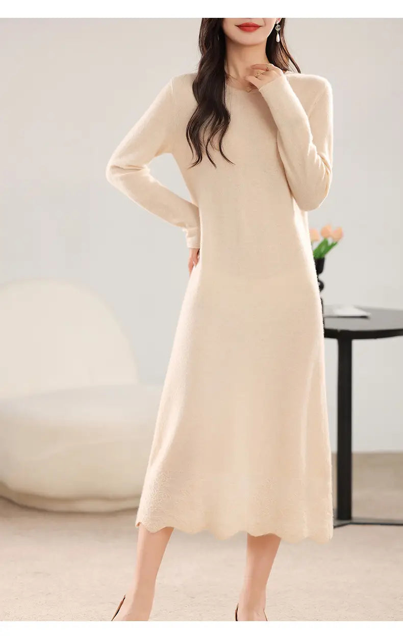 Ein Wollstrickkleid in Creme mit langen Ärmeln, Rundhalsausschnitt und gesäumtem Volantabschluss in Midi-Länge.