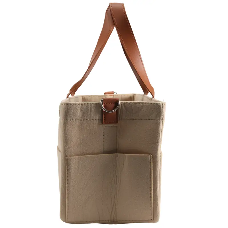 beige canvas felt baby diaper caddy nursery storage basket with tan leather handles and a matching leather strap at the top