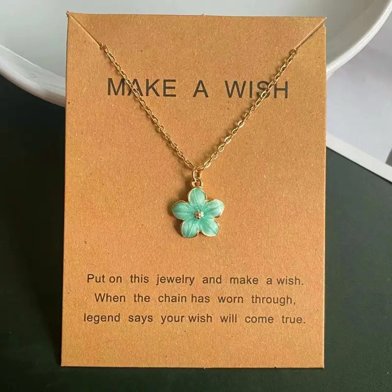 Un collier délicat en chaîne à maillons en or, avec un petit pendentif de fleur émaillée turquoise à cinq pétales, comprenant une minuscule pierre transparente au centre, idéal comme collier pendentif de fleur romantique et mignon.