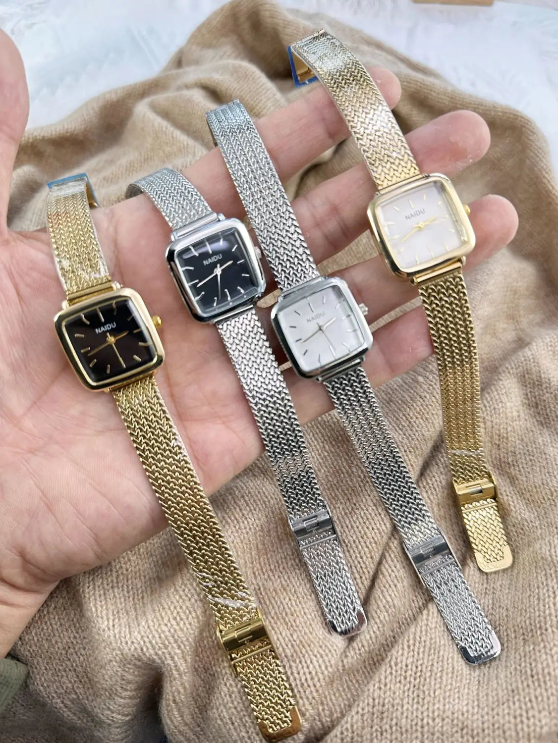 A collection of minimalist square quartz watches for women by hanqiu featuring gold and silver mesh bands with black white and cream dials.