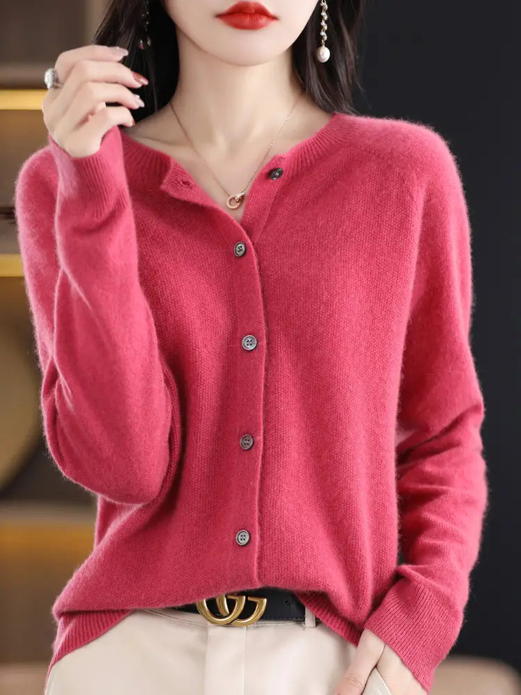 A soft vibrant pink merino wool cardigan for women featuring a classic button-front design and subtle ribbed cuffs.