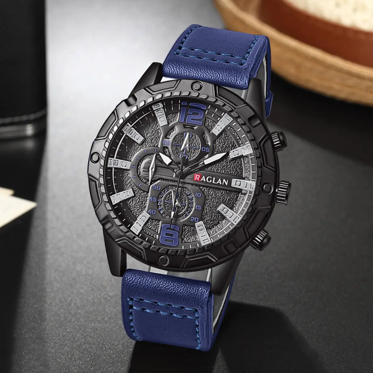 Montre à quartz pour homme avec chronographe, en cuir, avec bracelet en cuir bleu, boîtier noir et cadran à tons argentés doté de plusieurs compteurs.