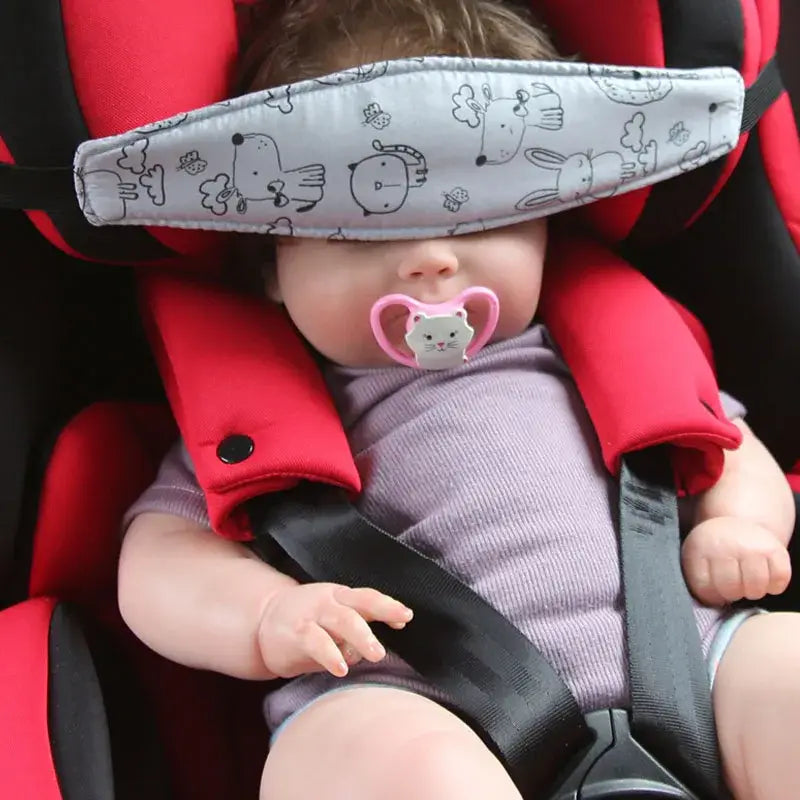 Kopfstützriemen für einen Babyschalen-Sitz verstellbarer Schlafpositionierer aus grauem Stoff mit schwarzen Cartoon-Tiermotiven, über die Augen des Babys getragen
