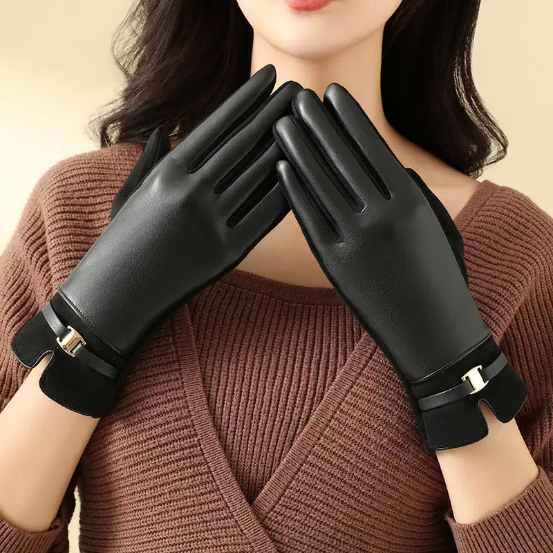 Schwarze Damen-Winterhandschuhe aus Leder mit einem eleganten, glatten Finish und silberfarbenen Schnallenakzenten am Handgelenk, von der Rückseite gezeigt, ausgelegt für die Verwendung mit Touchscreen.
