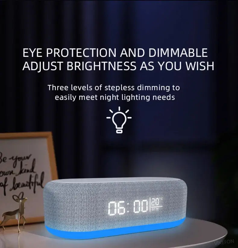 Grauer strukturierter Stoff-Lautsprecher mit Bluetooth-Funktion, kabellosem Laden und Alarmwecker mit blauer LED-Beleuchtungsbasis und digitaler Anzeige zur Anzeige der Uhrzeit und Temperatur, mit kabelloser Ladefunktion und Energiesparmodus.