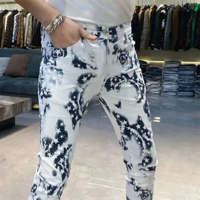 White denim jeans with a bold black abstract floral and star pattern in a men black floral slim fit jeans design.