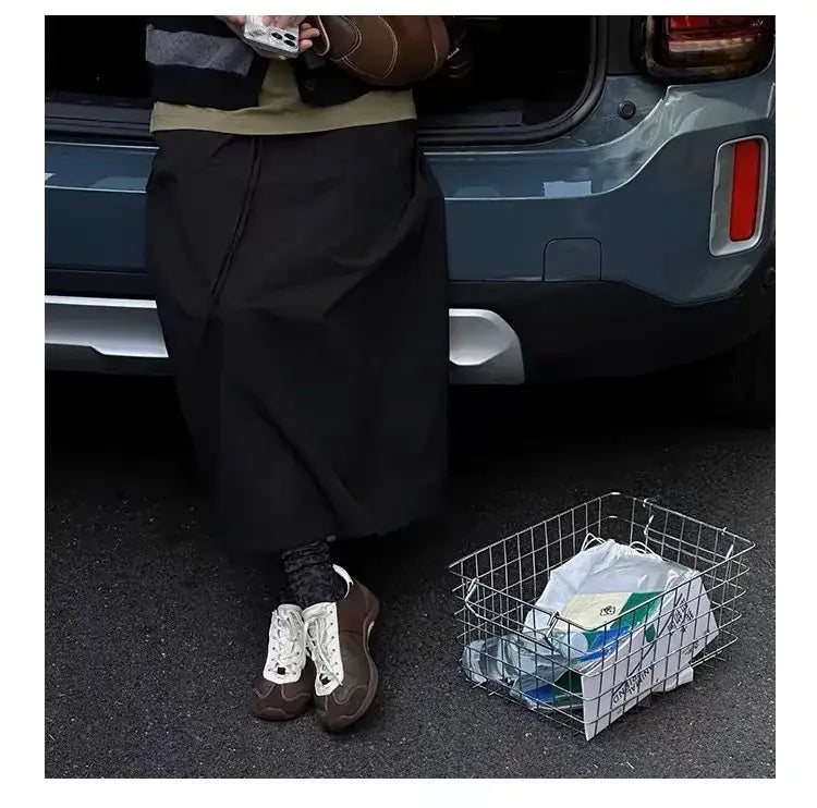 Panier noir en maille métallique contenant un sac à cordon blanc, aux côtés de baskets décontractées en daim pour femmes, légères et respirantes, chaussures de tennis blanches.