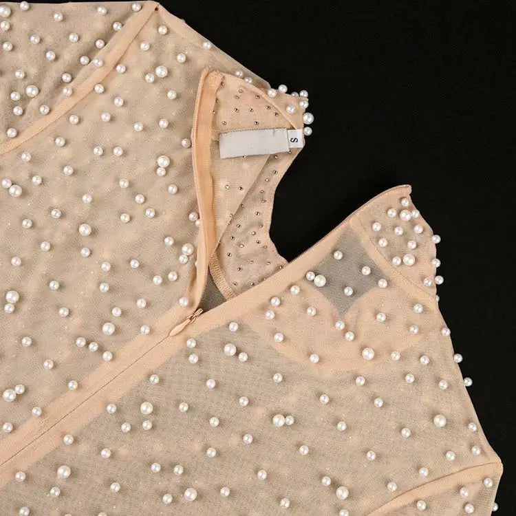 Beige beaded mesh jumpsuit featuring a sheer top adorned with scattered white pearls and a subtle shimmer for a high waist party outfit.