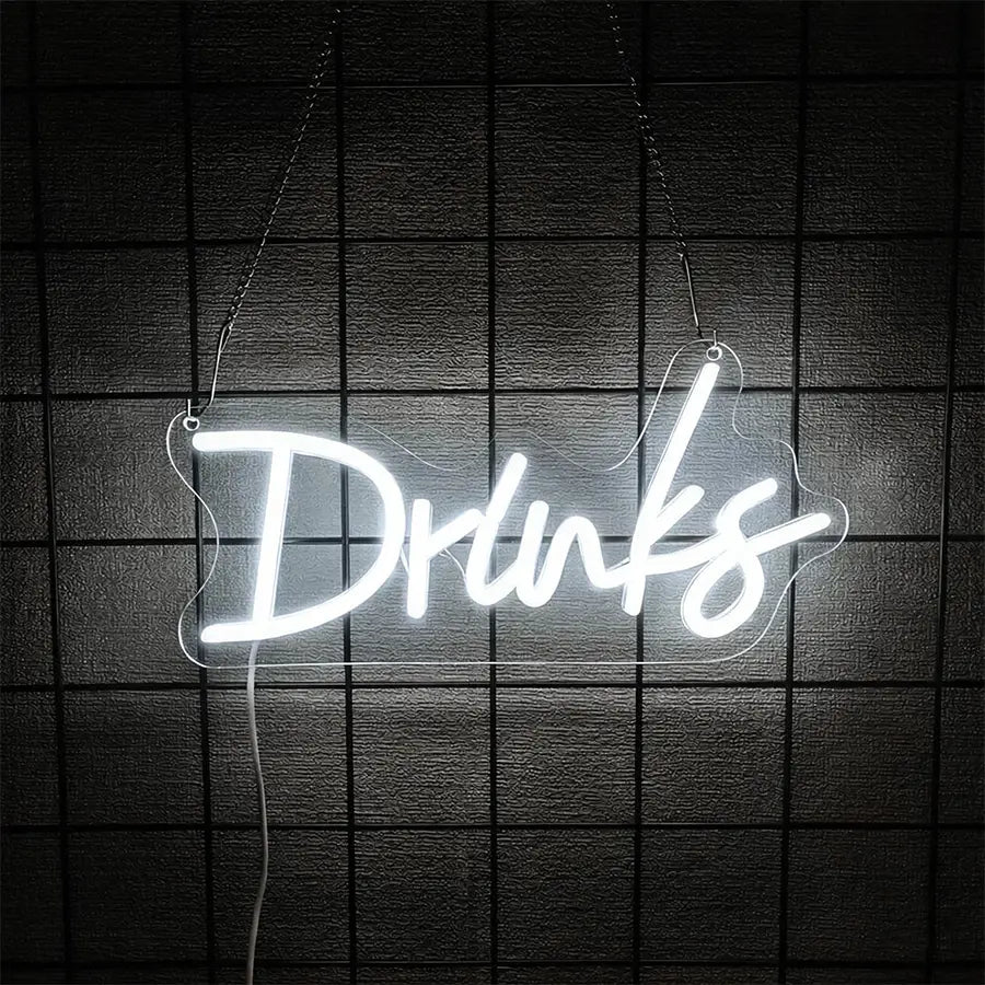 une enseigne au néon blanc lumineux avec le mot « drinks » dans une écriture cursive suspendue par des chaînes, en décoration murale à LED sur un fond sombre texturé
