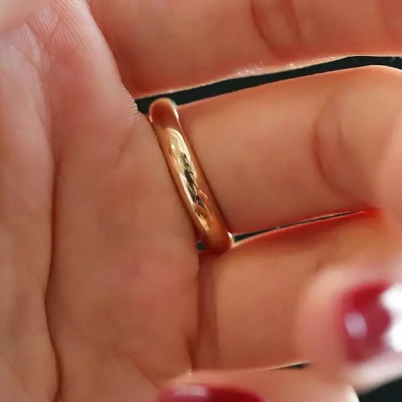 Un anillo de pareja de argollas de boda de oro de 18 quilates y 4 mm que presenta una banda pulida en color oro rosa, con un acabado pulido y suave.