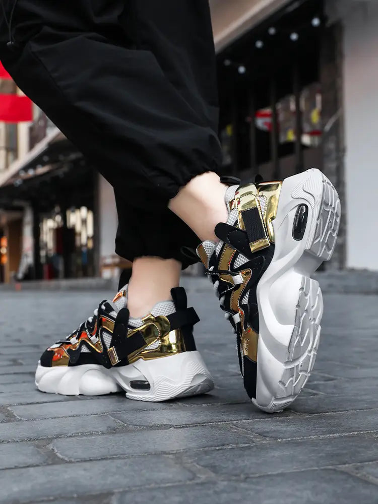 Men chunky air cushion casual sneakers in black and gold with white soles featuring a bold mesh and synthetic overlay design.