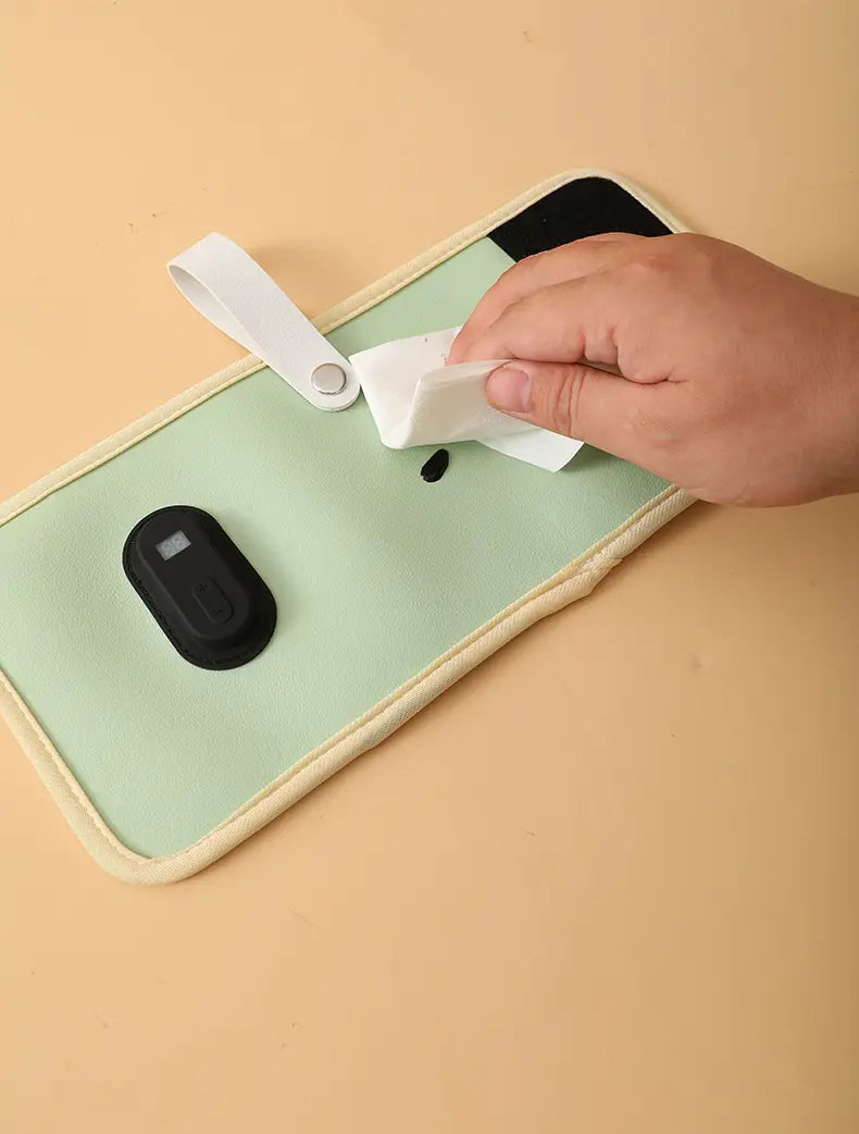 Tragbarer USB-Babyflaschenwärmer mit einer mintgrünen Stoff-Handytasche mit cremefarbenem Rand und einem weißen Handgelenkriemen.