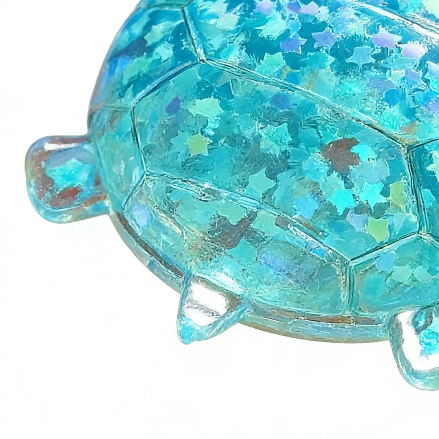 a translucent turquoise turtle shape squeeze toy made of soft material filled with iridescent star glitter designed as a sensory glitter turtle squeeze toy for stress relief