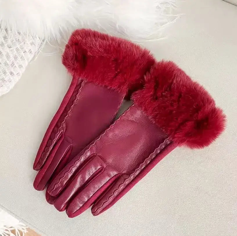 A pair of women’s fur-lined winter gloves in deep red leather with plush matching fur trim at the wrists.