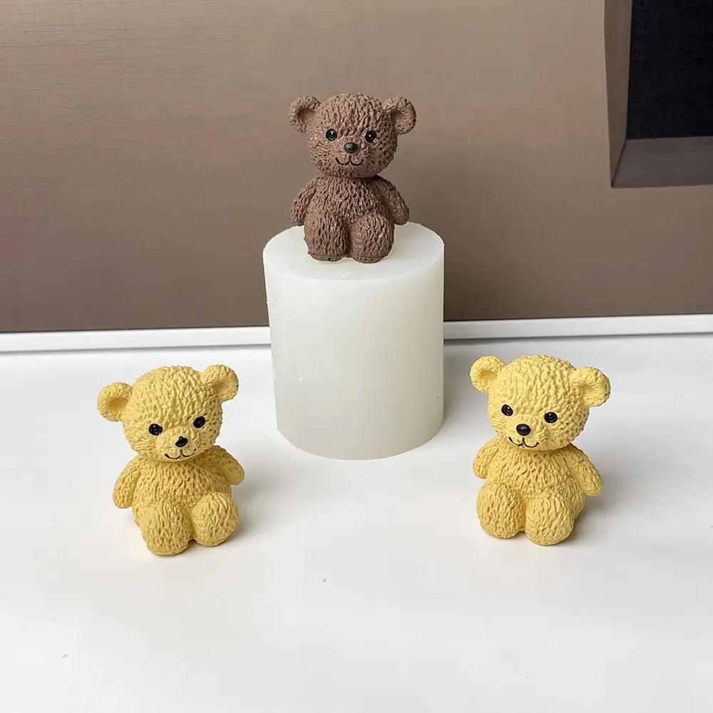 drei Miniatur-Teddybär-Figuren in braun und gelb mit glänzenden schwarzen Augen aus strukturiertem Harz, dargestellt als Teil einer Mini-Teddybär-Kerzenform.