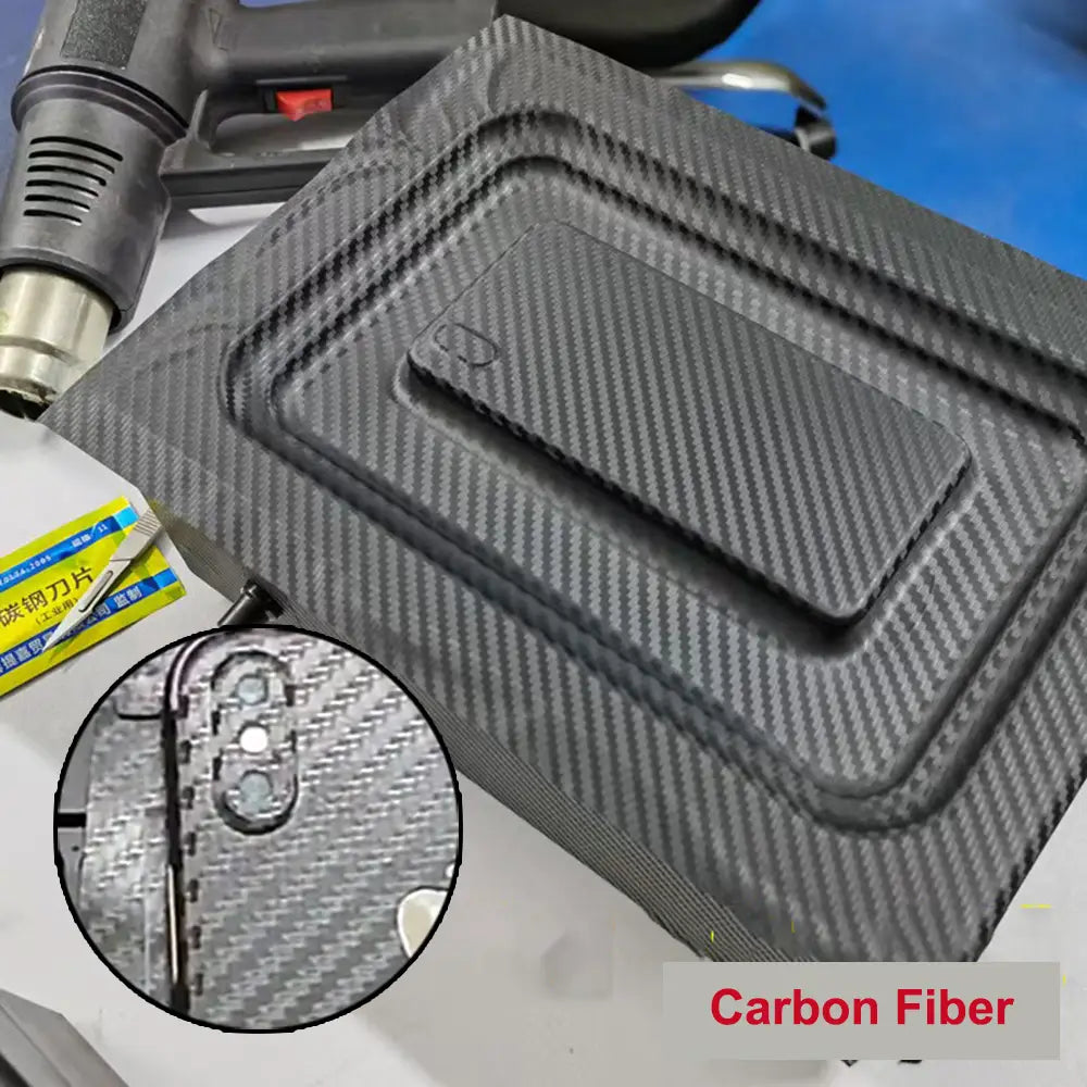 Funda para teléfono móvil negra de fibra de carbono, con patrón diagonal texturizado y tapa integrada para puerto de carga magnética, diseñada para el uso con una máquina de laminación al vacío de película para teléfonos móviles.
