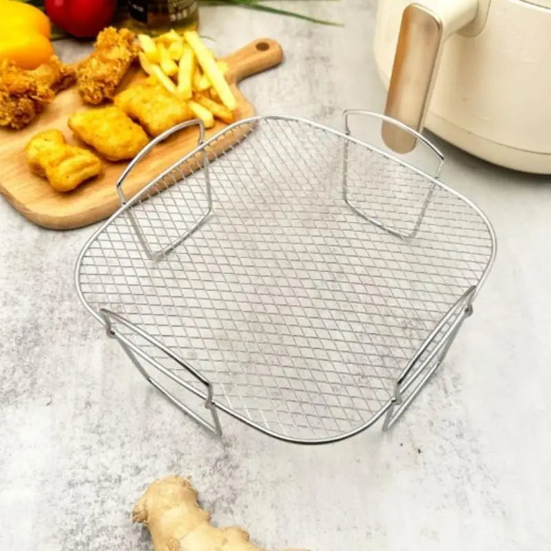 Silberner Luftfritteusen-Grillrost aus Edelstahl, stapelbarer Korb, mit Metallmaschen, verstärkten Griffen und quadratischem Gitterdesign.