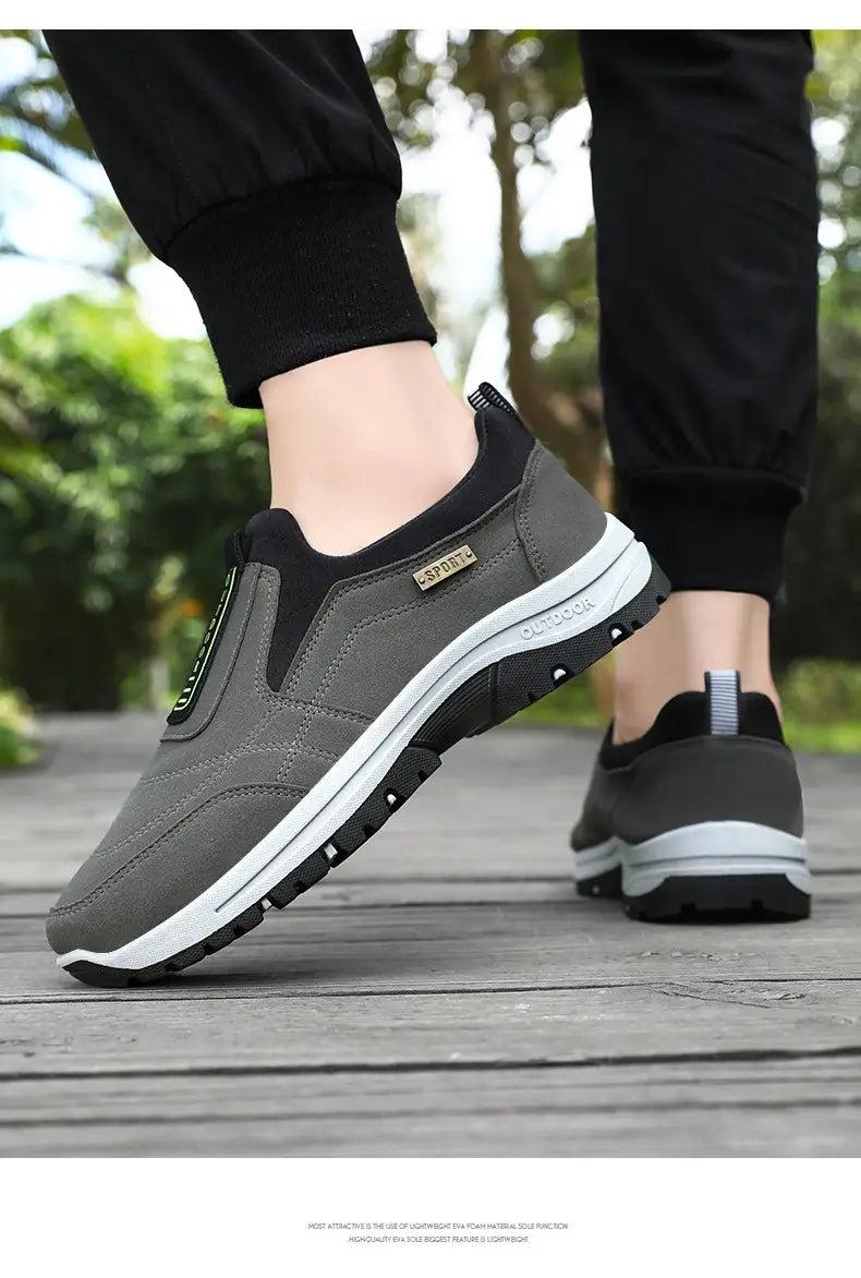 Men orthopedic slip-on walking shoes in gray and black with a white midsole and an outdoor label on the side designed for comfortable walking.