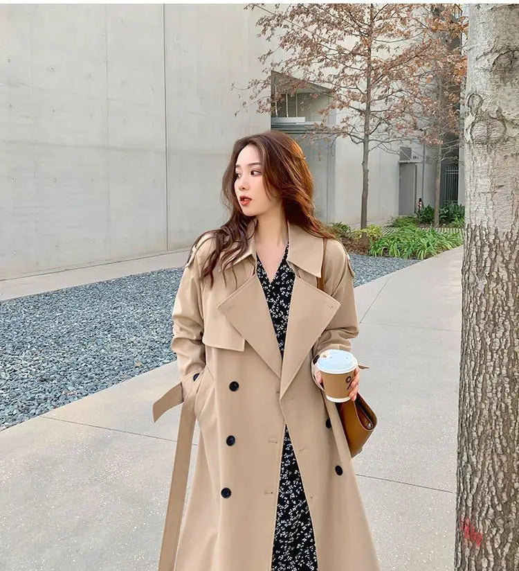 Women double breasted trench coat in beige with black buttons and a belted waist for a polished outerwear look