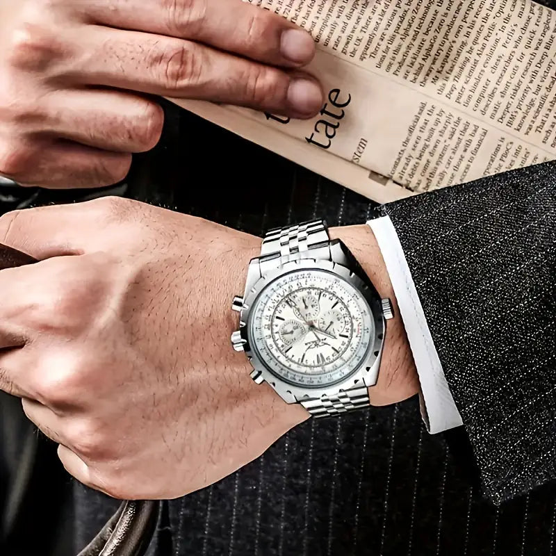 Mechanical stainless steel men’s chronograph watch with a silver-toned stainless steel case, white dial, and multiple subdials worn on a man’s wrist.