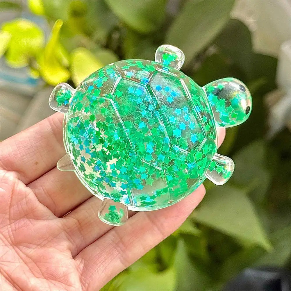 Ein durchscheinender grüner Schildkröten-Spielzeug-Fidget-Spielzeug-Stressball aus weichem Material, gefüllt mit schimmerndem blauem und türkisfarbenem Stern-Konfetti, für Stresslinderung und Zusammendrücken.