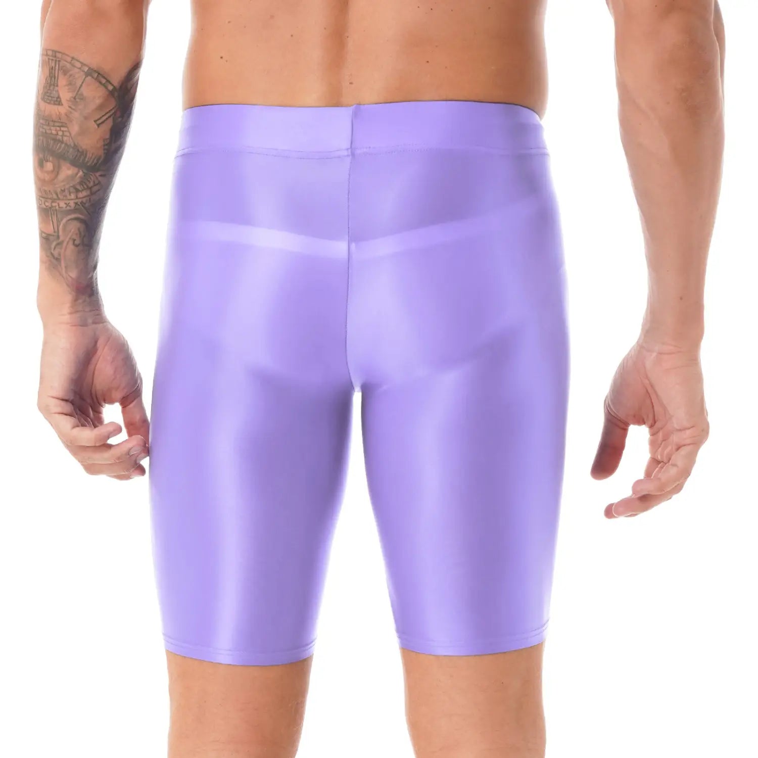Shorts de látex morados brillantes combinados con una camiseta de compresión para hombre de manga larga y acabado brillante, que destacan un look deportivo elegante y de ajuste ceñido