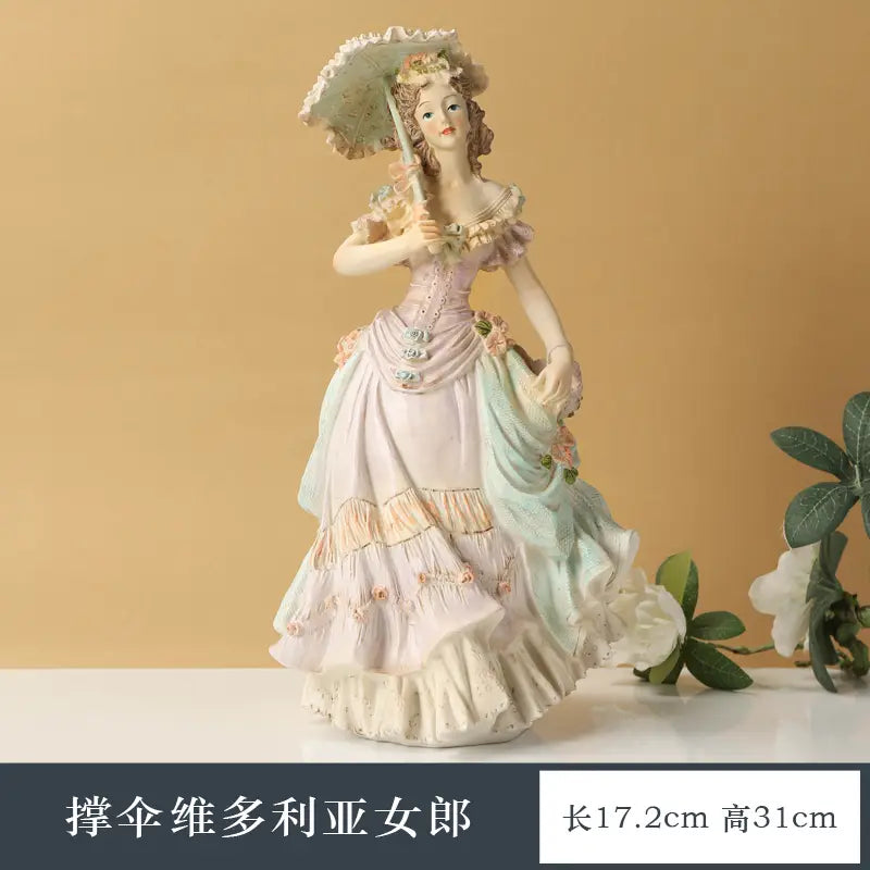 A delicate porcelain figurine of a Victorian-era woman in an ornate pastel layered gown with floral embellishments holding a lace parasol for home decor from the Victorian couple resin figurine collection.