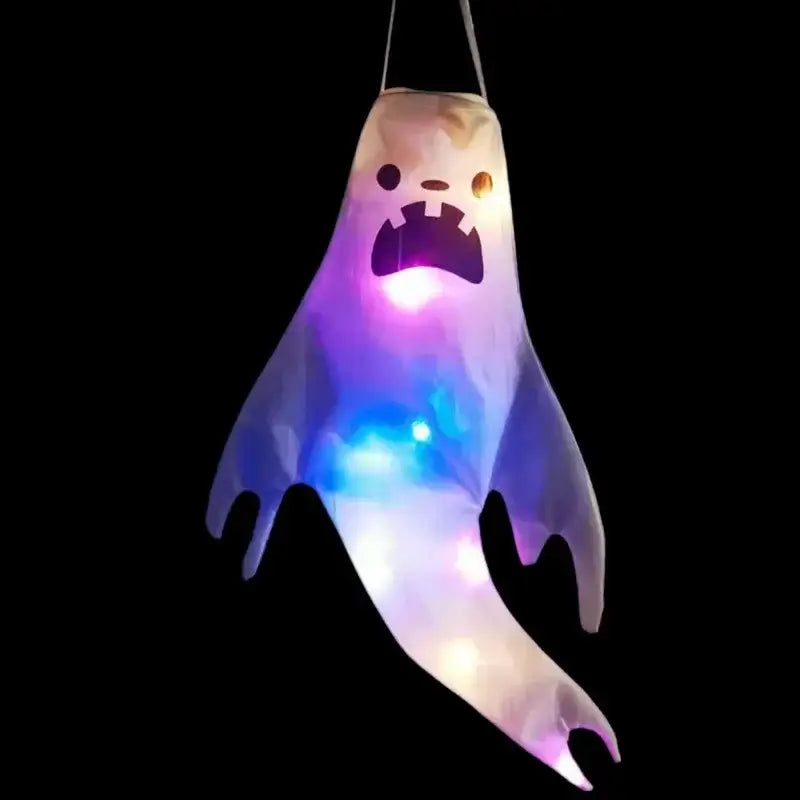 A glowing purple and blue led halloween ghost lantern with a cartoonish face hanging by strings for home outdoor use.