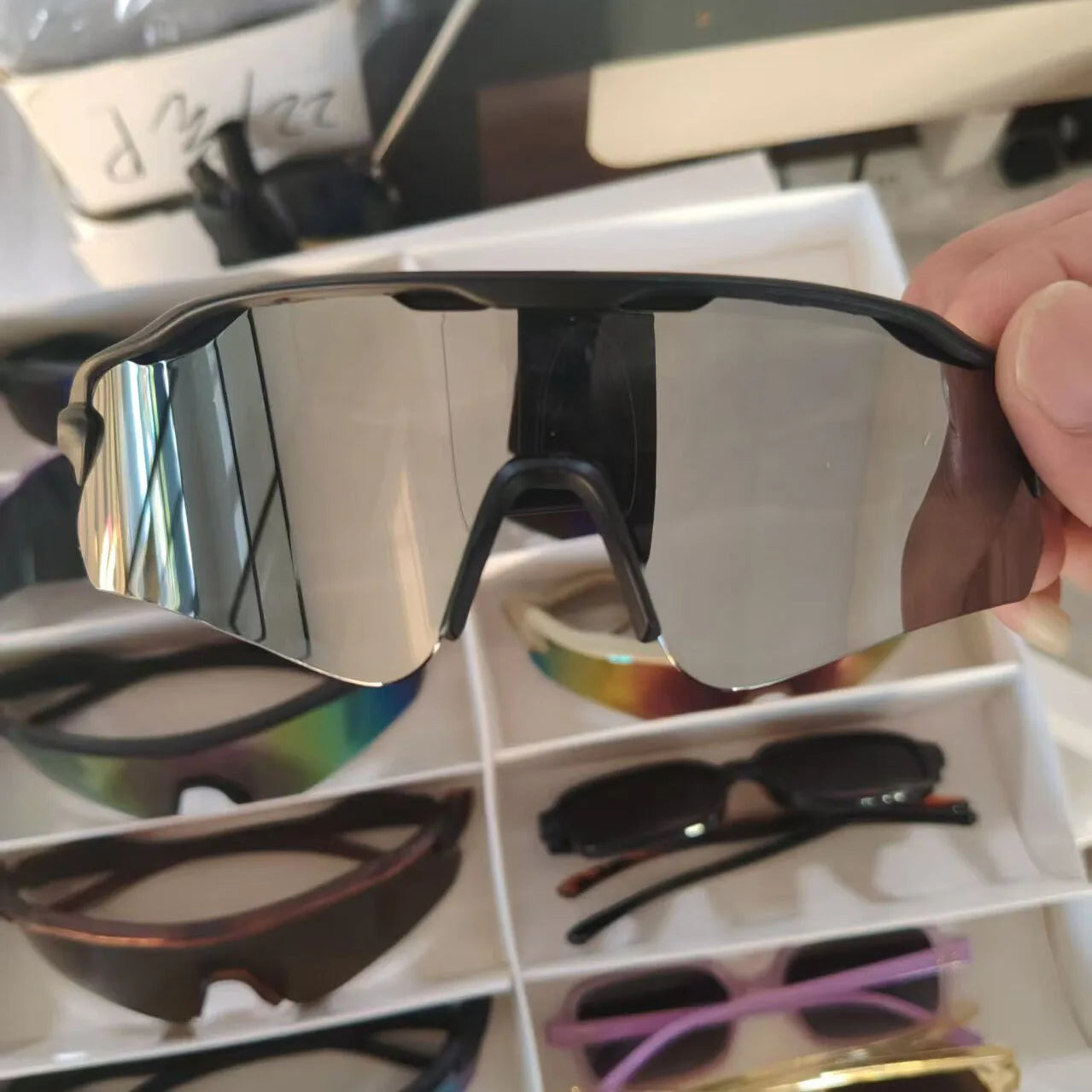 Gafas de sol deportivas polarizadas para hombre con montura de marco negro y lentes plateadas reflectantes que ofrecen protección UV.